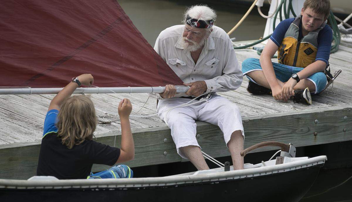 Captain Horatio Sinbad and his grandson Christian Torkington, left, and Christian Stevens, right, rig a small sailboat on Monday, June 25, 2018 in Beaufort, N.C.