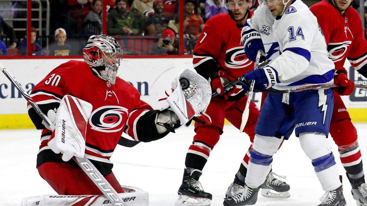 The Canes' Cam Ward (30) snags puck in NHL game between Carolina Hurricanes and Tampa Bay at PNC Arena on April 7, 2018.
