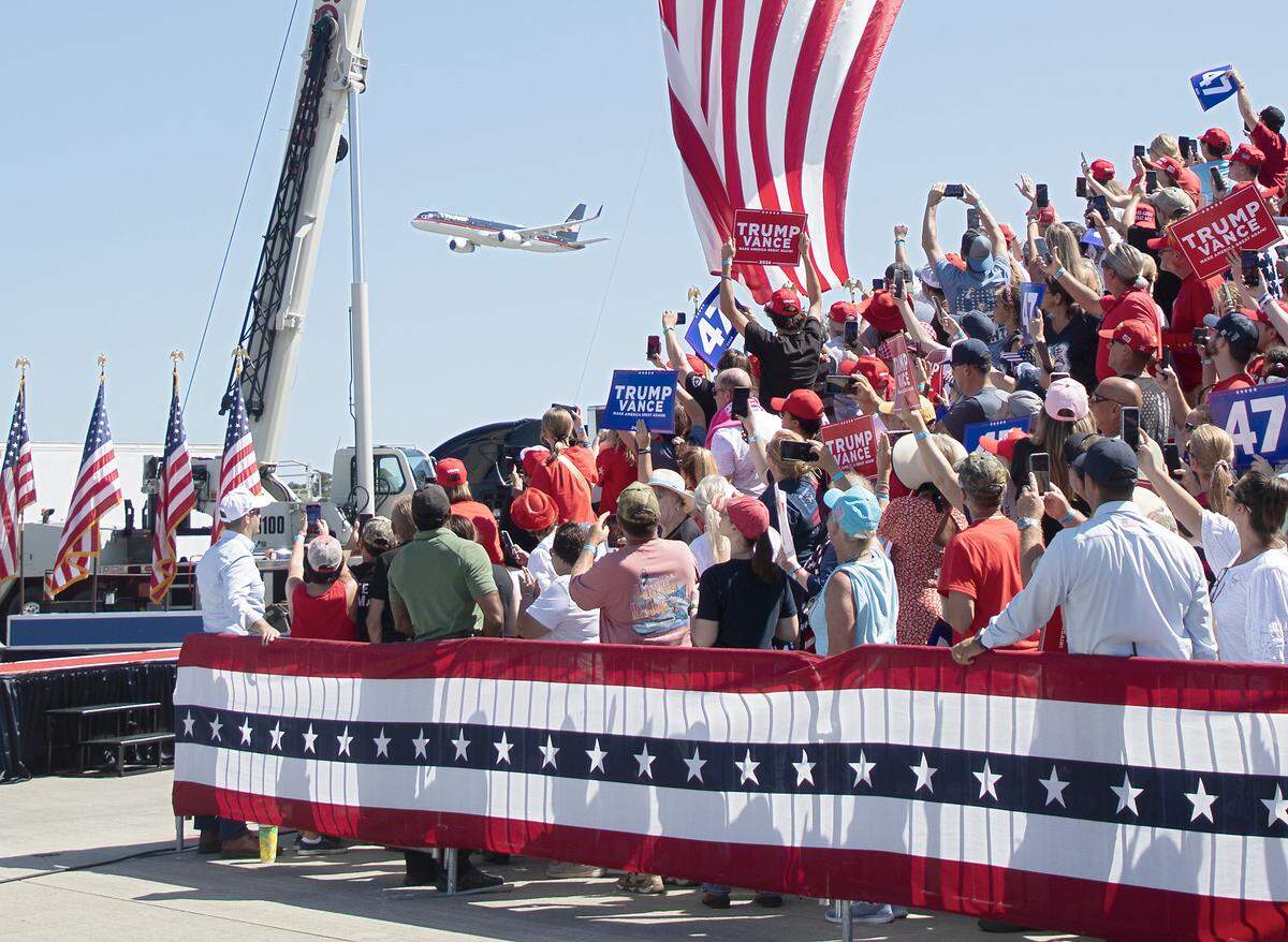 The plane of former President and current Republican candidate for president Donald Trump flies over the crowd prior to a rally in Wilmington, N.C. on Saturday, Sept. 21, 2024.