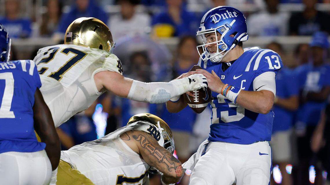 Duke’s Riley Leonard looks to pass under pressure from Notre Dame’s JD Bertrand and Jordan Botelho during the first half of the Blue Devils’ game at Wallace Wade Stadium on Saturday, Sept. 30, 2023, in Durham, N.C.