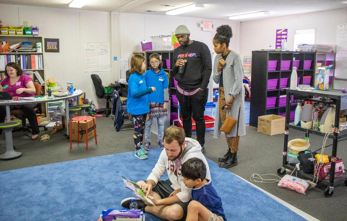 Parents Jocolby Harrell, 37, left, and Meka Harrell, 38, visit a first-grade classroom during a student-led tour of Exploris School, a public charter elementary school, during its open application period for prospective families on Tuesday, Feb. 4, 2020, in Raleigh, N.C. Exploris recently received a grant to prioritize economically disadvantaged students in its lottery system.