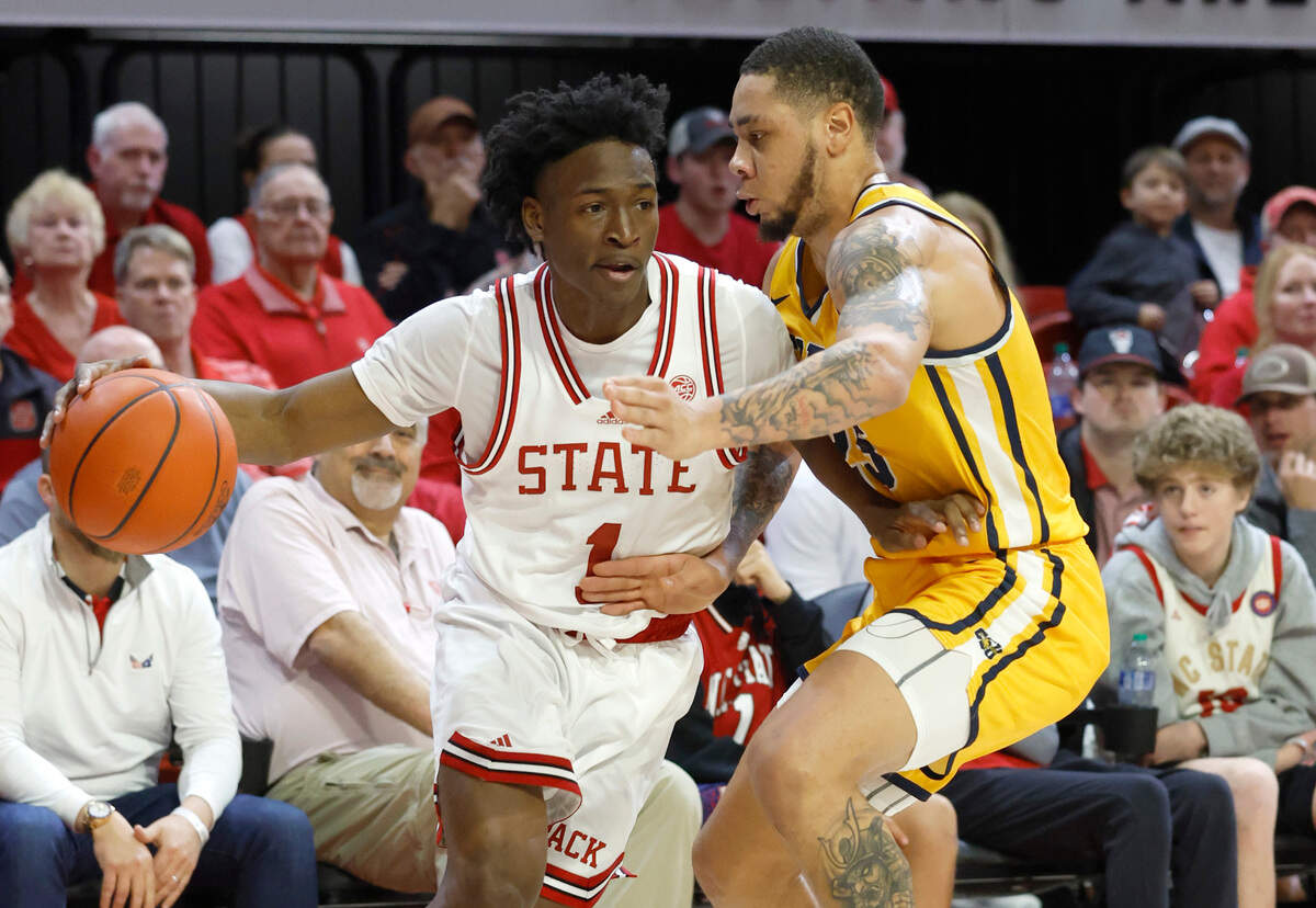 N.C. State’s Jarkel Joiner (1) looks to drive by Coppin State’s Isaiah Gross (25) during the first half of N.C. State’s game against Coppin State at Reynolds Coliseum in Raleigh, N.C., Tuesday, Dec. 6, 2022.