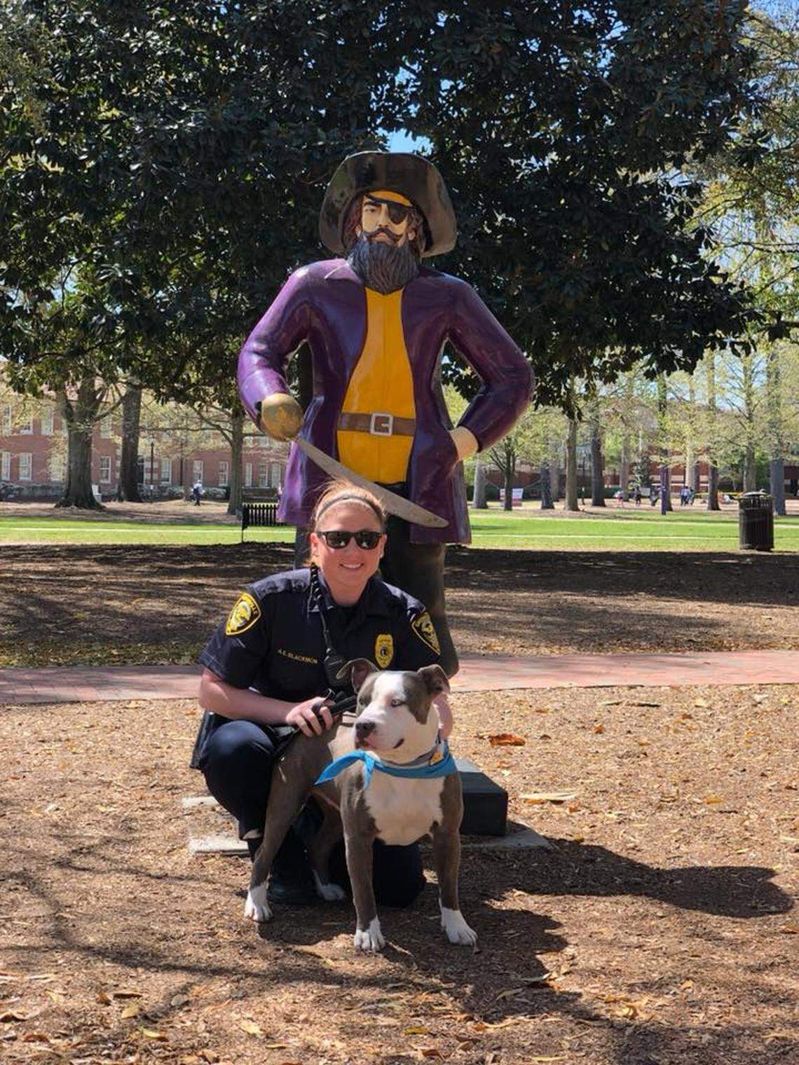 Harvard the rescue dog poses with a Greenville police officer on East Carolina Univeristy's campus.