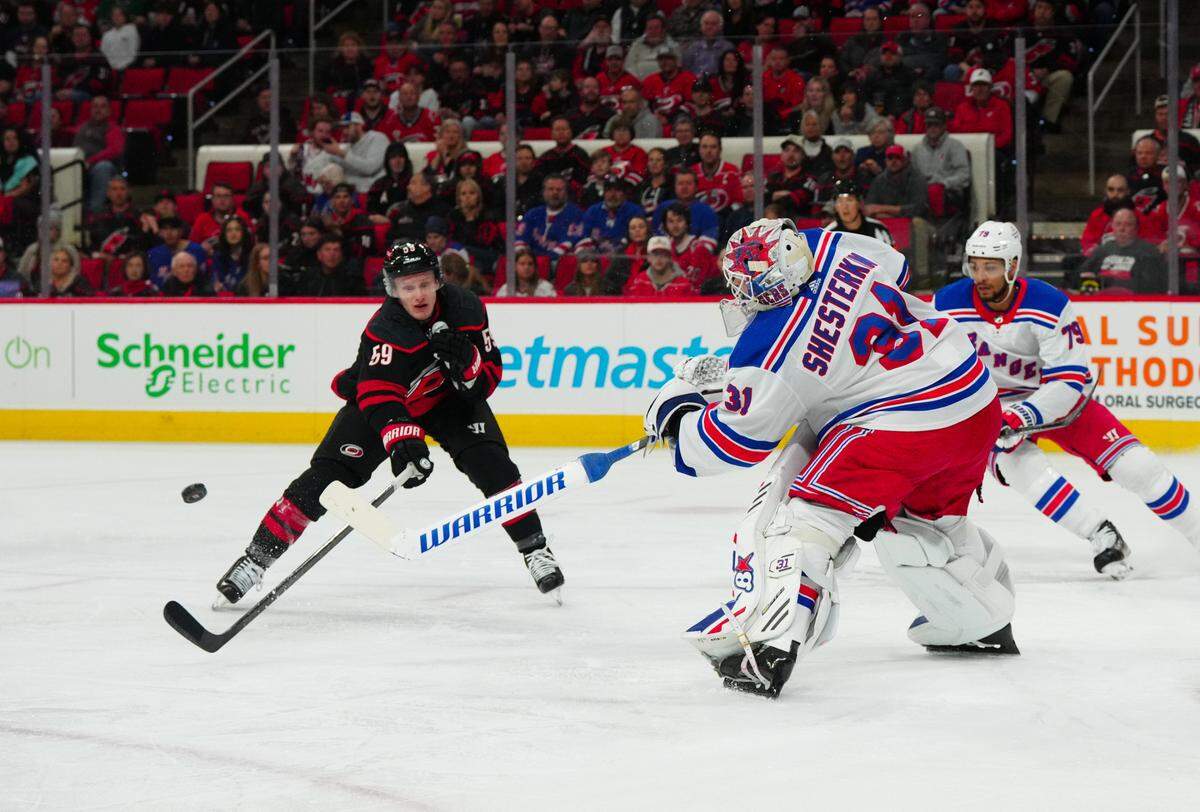 Mar 12, 2024; Raleigh, North Carolina, USA; New York Rangers goaltender Igor Shesterkin (31) clears the puck away from Carolina Hurricanes left wing Jake Guentzel (59) during the first period at PNC Arena.