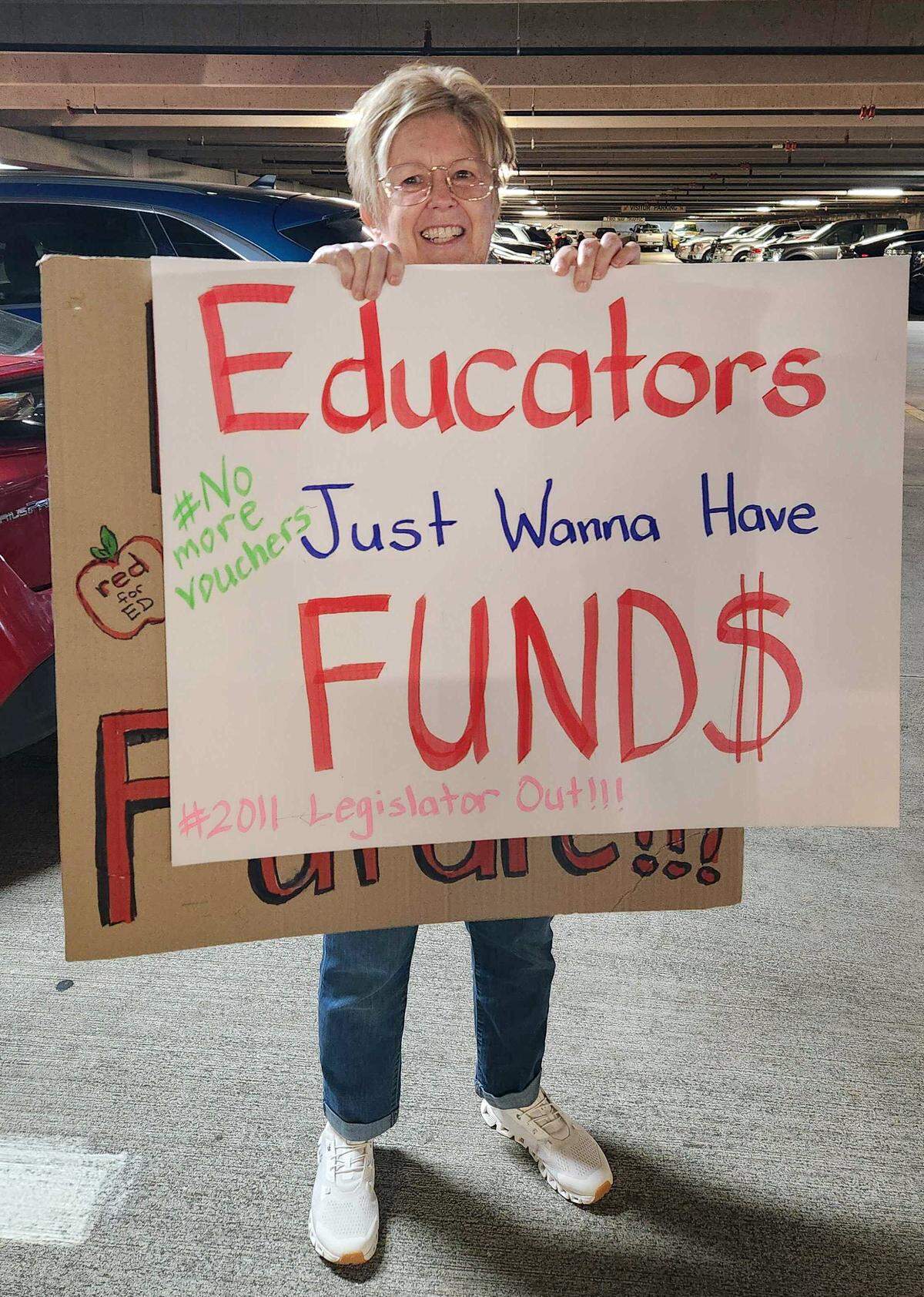 Lynda Lee of Greenville holds up her "Educators Just Wanna Have Fund<!-- %asset:315599087% -->quot; sign as she arrived for the teacher march, parking in a downtown garage across from Halifax Mall. Lee has taught since 1970 and now works part-time at Elmhurst Elementary School in Pitt County.