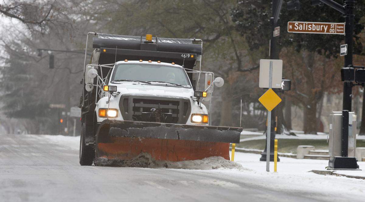 A plow helps clear W Edenton Street in downtown Raleigh Sunday morning, Jan. 25, 2026.