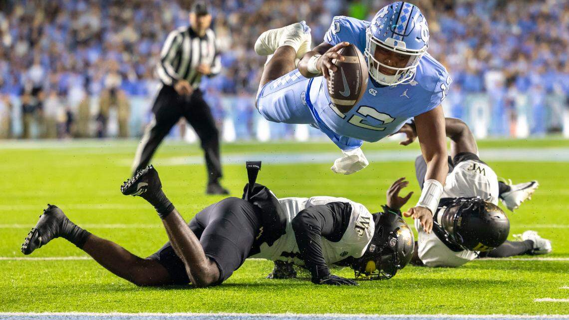 North Carolina quarterback Jacolby Criswell (12) dives over Wake Forest defensive back Zamari Stevenson (17) to score on a 4-yard run to give the Tar Heels a 7-3 lead in the second quarter on Saturday, November 16, 2024 at Kenan Stadium in Chapel Hill, N.C.