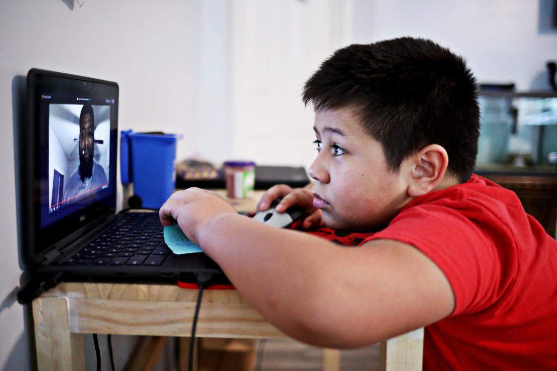 Gael Obregon, 8, whose home language is Spanish, looks over homework for his online school classes at his Durham home on Oct. 28, 2020. Obergon and his mother, Patricia, struggle with his school’s English-only online learning system.