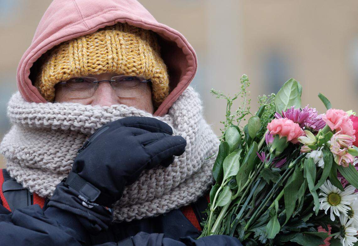 A supporter holds a bouquet of flowers while awaiting a procession of Buddhist monks at Dorothea Dix Park on Saturday.