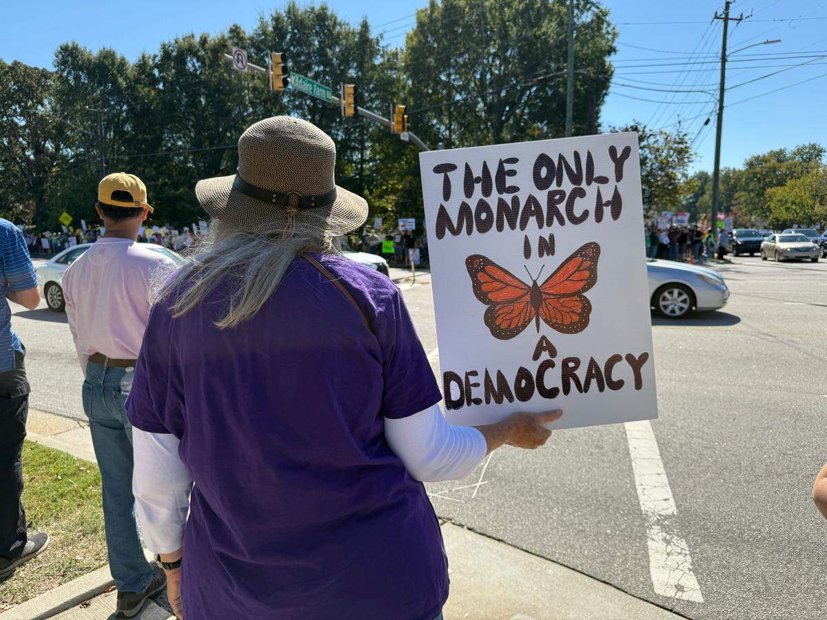 A No Kings protester’s sign plays off of the Monarch butterfly in Cary.