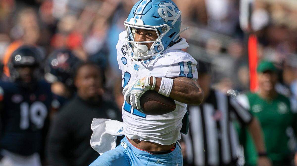 North Carolina’s Josh Downs (11) looks for running room against Virginia’s Coen King (9) after a 32-yard pass reception from quarterback Drake Maye in the third quarter on Saturday, November 5, 2022 at Scott Stadium in Charlottesville, Va. Downs had 15 pass receptions for 166 yards in the Tar Heels’ victory.