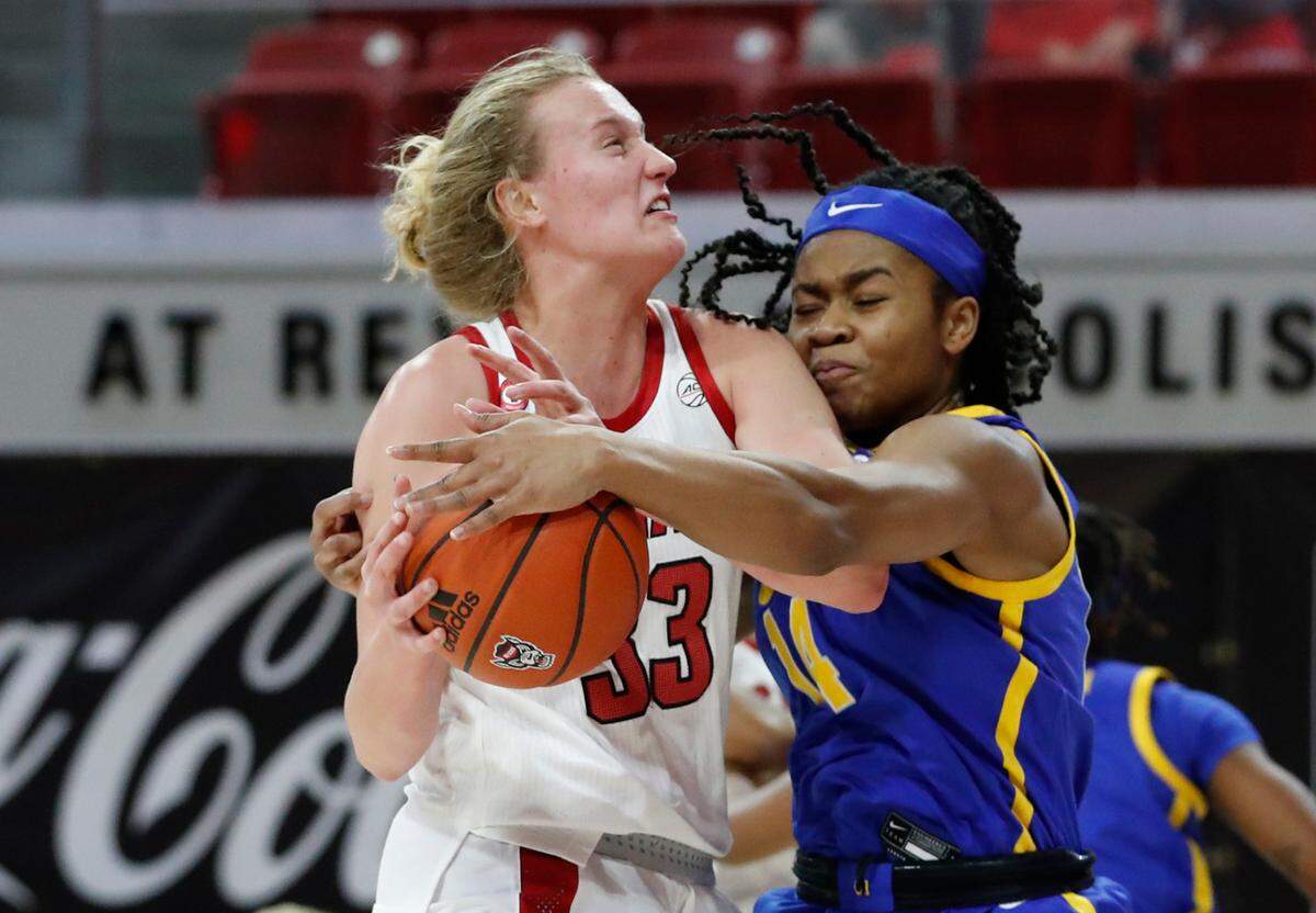 Pittsburgh’s Cynthia Ezeja (14) knocks the ball from the hands of N.C. State’s Elissa Cunane (33) during the first half of N.C. State’s game against Pittsburgh at Reynolds Coliseum in Raleigh, N.C., Thursday, February 25, 2021.