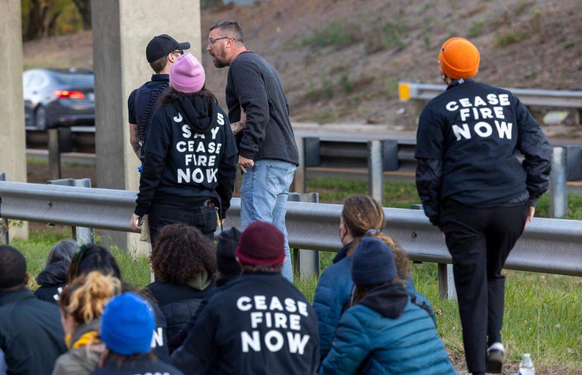 A police officer tries to calm an irate motorist as protesters block the northbound lanes of the Durham Freeway at the South Magnum Street bridge for hours Thursday evening, Nov. 2, 2023 while demanding a ceasefire in the Israel-Gaza War.