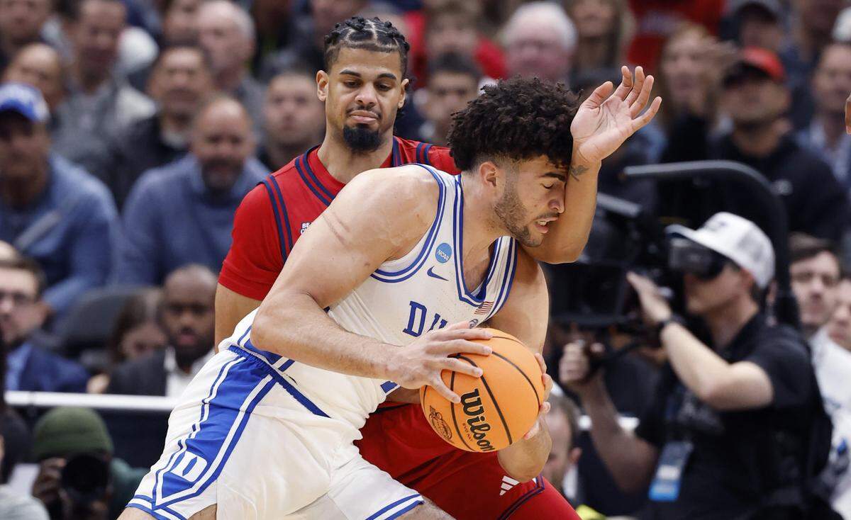 Duke’s Cameron Boozer (12) drives past St. John's Bryce Hopkins (23) during the first half of Duke’s game against St. John’s in the Sweet 16 of the NCAA Men’s Basketball East Regional at Capital One Arena in Washington, D.C., Friday, March 27, 2026.