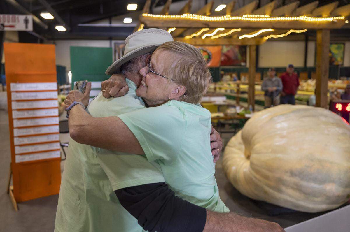 Lois Nelson of Thomas, West Virginia, embraces Albert Rodebaugh after his pumpkin weighed in at 2,244.5 pounds. Rodebaugh won the 2025 competition.