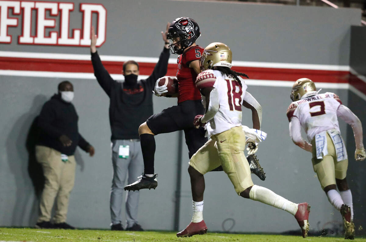 N.C. State wide receiver Thayer Thomas (5) heads into the end zone in front of Florida State defensive back Travis Jay (18) on 24-yard touchdown reception during the second half of N.C. State’s 38-22 victory over Florida State at Carter-Finley Stadium in Raleigh, N.C., Saturday, Nov. 14, 2020.