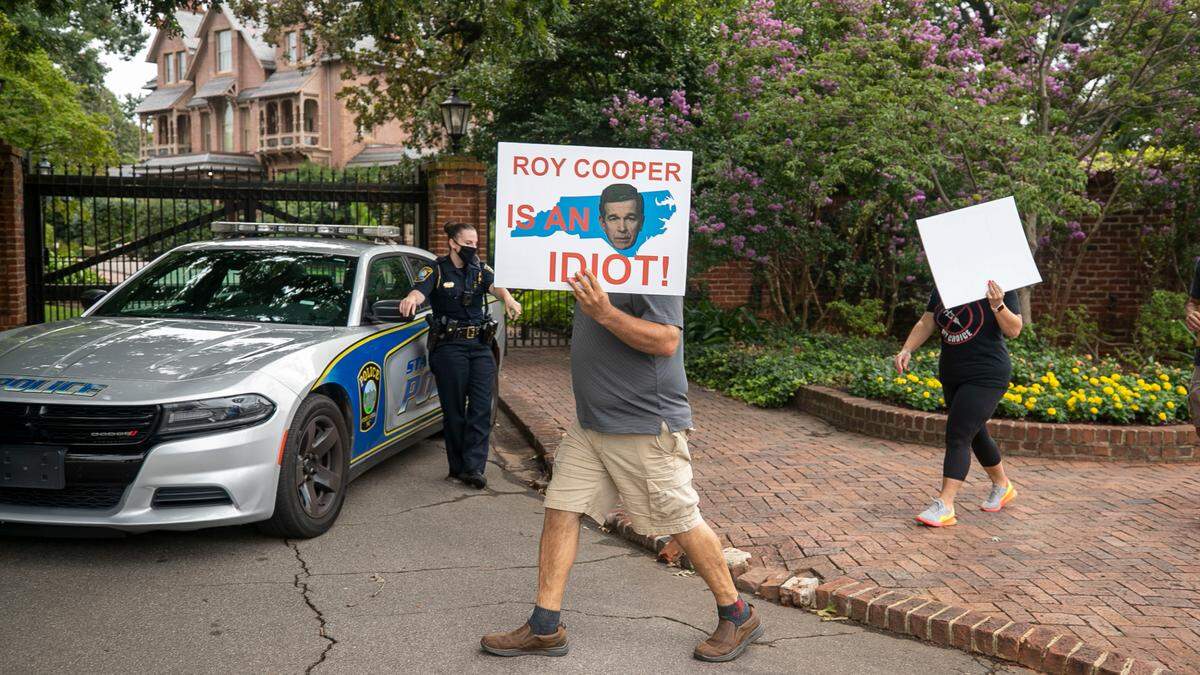 Demonstrators march around The Executive Mansion calling for an end to mandated masks and COVID-19 vaccinations by some employers and schools on Wednesday morning, August 4, 2021 in Raleigh, N.C.