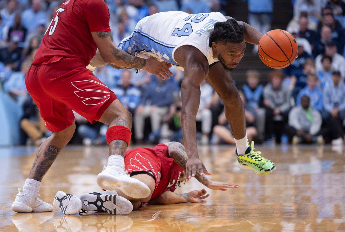 North Carolina’s Jae’Lyn Withers (24) recovers a loose ball over Louisville’s Tre White (22) in the second half on Wednesday, January 17, 2024 at the Smith Center in. Chapel Hill, N.C.