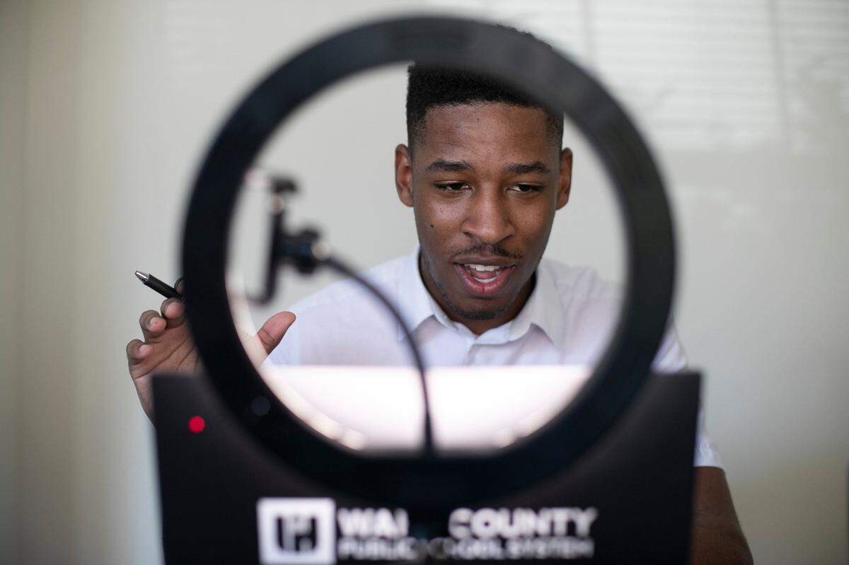 Enloe High School special education teacher Tyler Swanson works with his freshman English class remotely from his dining room table in his apartment on Monday, August 17, 2020, in Cary, N.C. Swanson is now chair of the Wake County school board.
