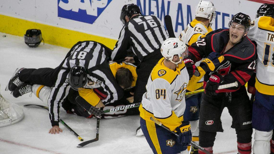 Carolina Hurricanes Brett Pesce (22) tangles with Nashville’s Tanner Jeannot (84) while officials try to break up a fight between Carolina Hurricanes’ Jordan Martinook (48) and Nashville’s Matt Benning (5) in the second period during game two of their first round Stanley Cup playoff series on Wednesday, May 19, 2021 at PNC Arena in Raleigh, N.C.