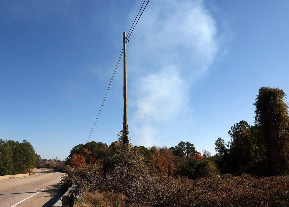 Smoke billows above the treetops near Gresham Lake Road and Interstate 540 as a fire burns at Wall Recycling Raleigh on Tuesday, Nov. 29, 2022, in Raleigh, N.C.