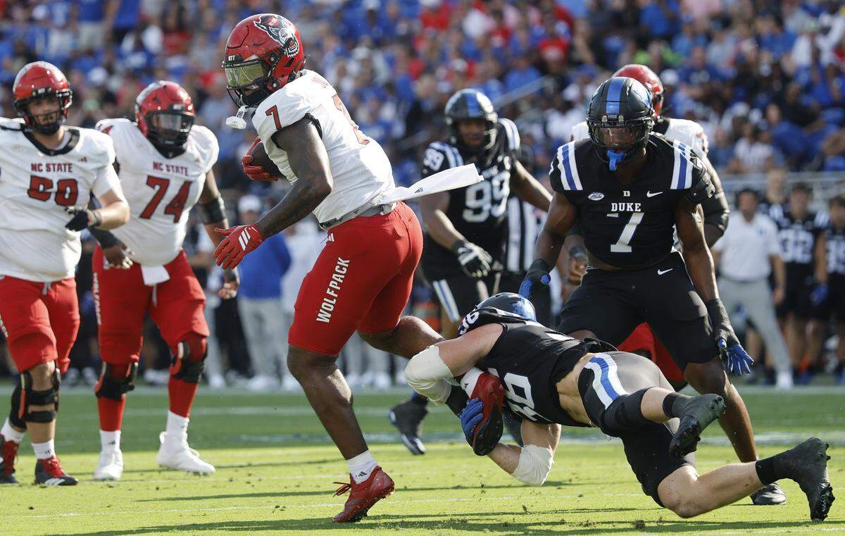 N.C. State tight end Justin Joly (7) avoids the tackle by Duke linebacker Nick Morris Jr. (36) during the first half of N.C. State’s game against Duke at Wallace Wade Stadium in Durham, N.C., Sat. Sept. 20, 2025