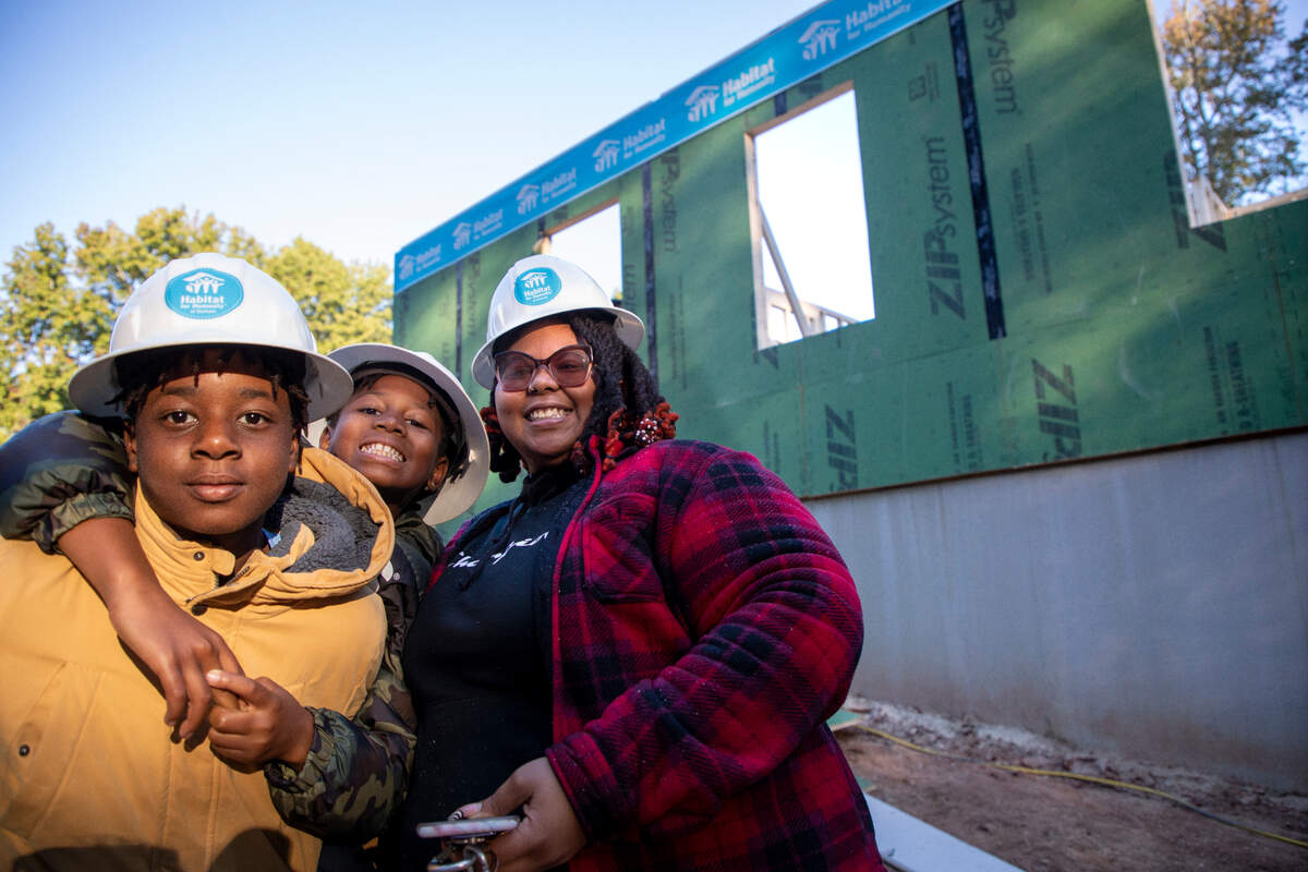 First-time Habitat homeowner Pateryl Hargett, 33, is pictured with her sons, aged 10 and 13, in front of her home under construction at 712 Belmont Dr. in Durham.