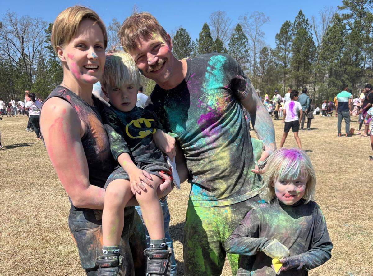 Kate Hanson and Will Greczyn of Garner and their two children, Bob and Mina, celebrate Morrisville’s 4th annual Holi festival on Saturday. A big part of the event is throwing powders of several colors on other festival goers.