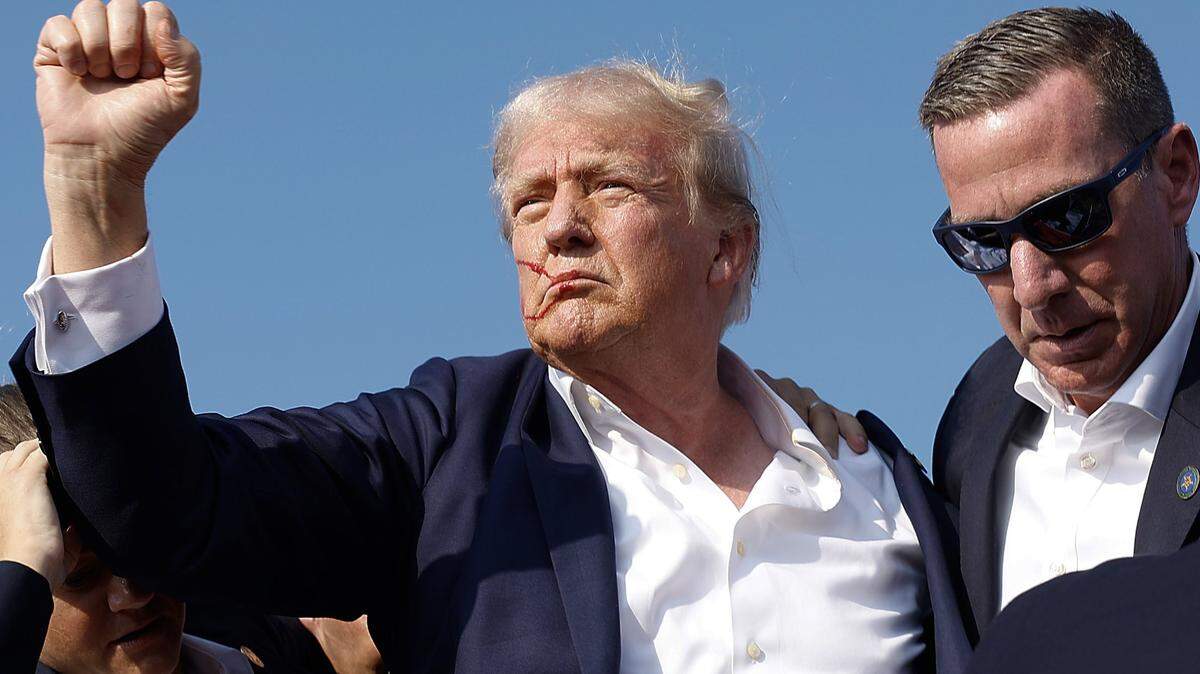 Republican presidential candidate former President Donald Trump pumps his fist as he is rushed offstage by Secret Service agents after being grazed by a bullet during a campaign rally on Saturday, July 13, 2024, in Butler, Pennsylvania.