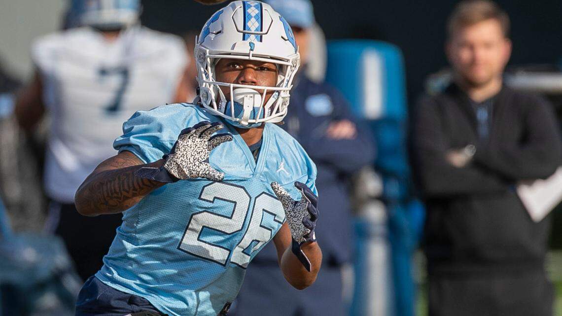 North Carolina running back D.J. Jones (26) concentrates on a pass from quarterback Jacolby Criswell (6) during the opening day of the Tar Heels’ spring football practice on Tuesday, March 1, 2022 in Chapel Hill, N.C.