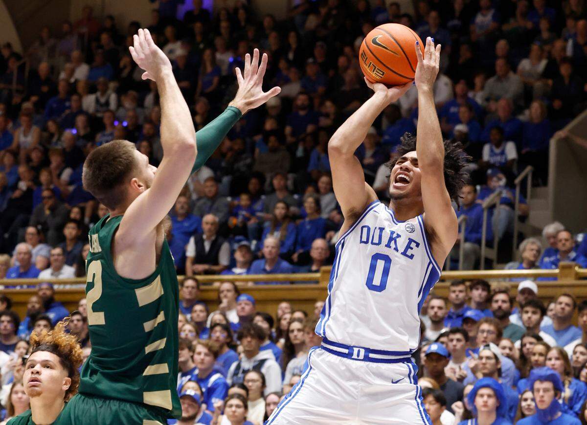 Duke’s Jared McCain (0) shoots as Charlotte’s Jackson Threadgill (12) defends during the first half of Duke’s game against Charlotte at Cameron Indoor Stadium in Durham, N.C., Saturday, Dec. 9, 2023.