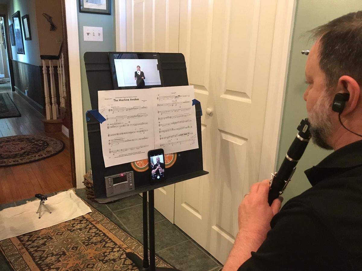 Nick Bandarenko, associate professor of pathology, is a clarinet player with the Durham Medical Orchestra, a community symphony orchestra open to musicians who work in the health sciences field. He records his part of “The Machine Awakes” while watching a video playback of conductor Verena Mösenbichler-Bryant. The musicians collaborated for a virtual premiere.