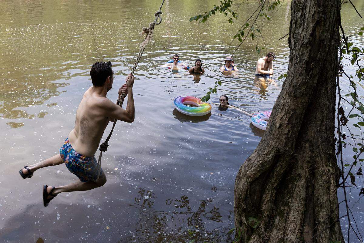 Matt Howes leaps over the water from a rope swing at Sennett’s Hole on the Eno River on Monday, July 3, 2023, in Durham, N.C.