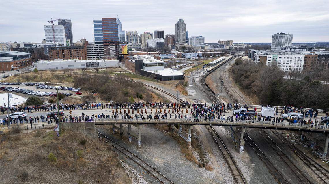 A procession of Buddhist monks walks across Boylan Bridge in downtown Raleigh, followed by hundreds of well-wishers on Saturday, Jan. 24, 2026. The monks are making a 2,300-mile pilgrimage from Texas to Washington, D.C., as part of the Walk for Peace, an effort to promote peace, compassion and national unity.