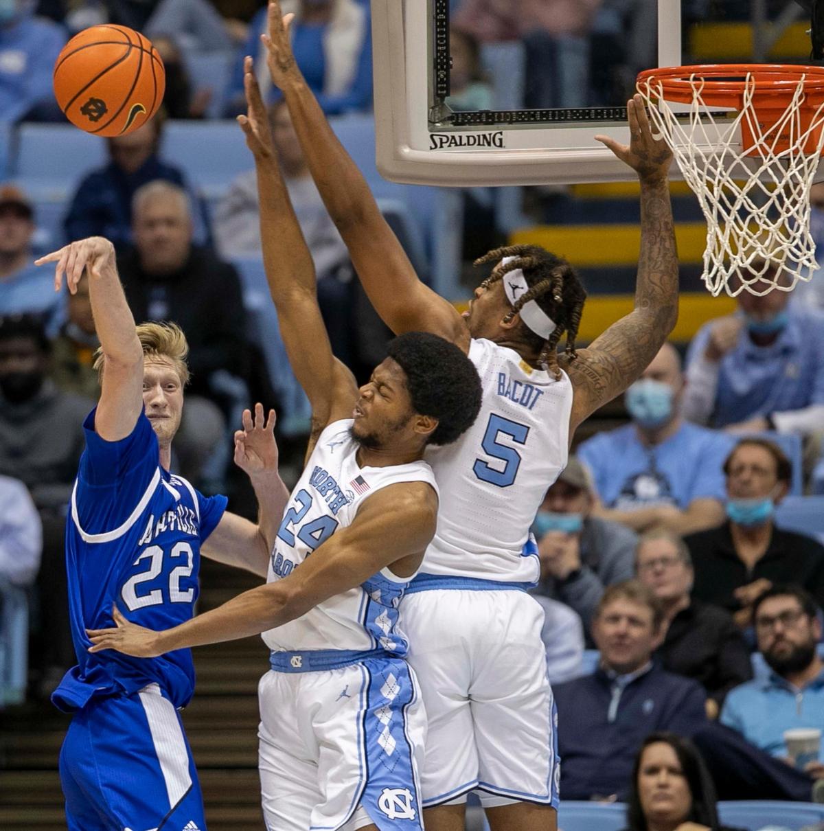 North Carolina’s Armando Bacot (5) and Kerwin Walton (24) defend UNC-Asheville’s Coty Jude (22) in the second half on Tuesday, November 23, 2021at the Smith Center in Chapel Hill, N.C.
