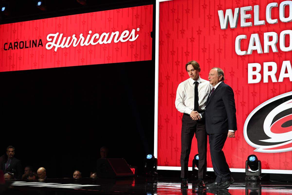 Carolina Hurricanes draft pick Bradly Nadeau shakes hands with NHL commissioner Gary Bettman after being selected with the thirtieth pick in round one of the 2023 NHL Draft at Bridgestone Arena.