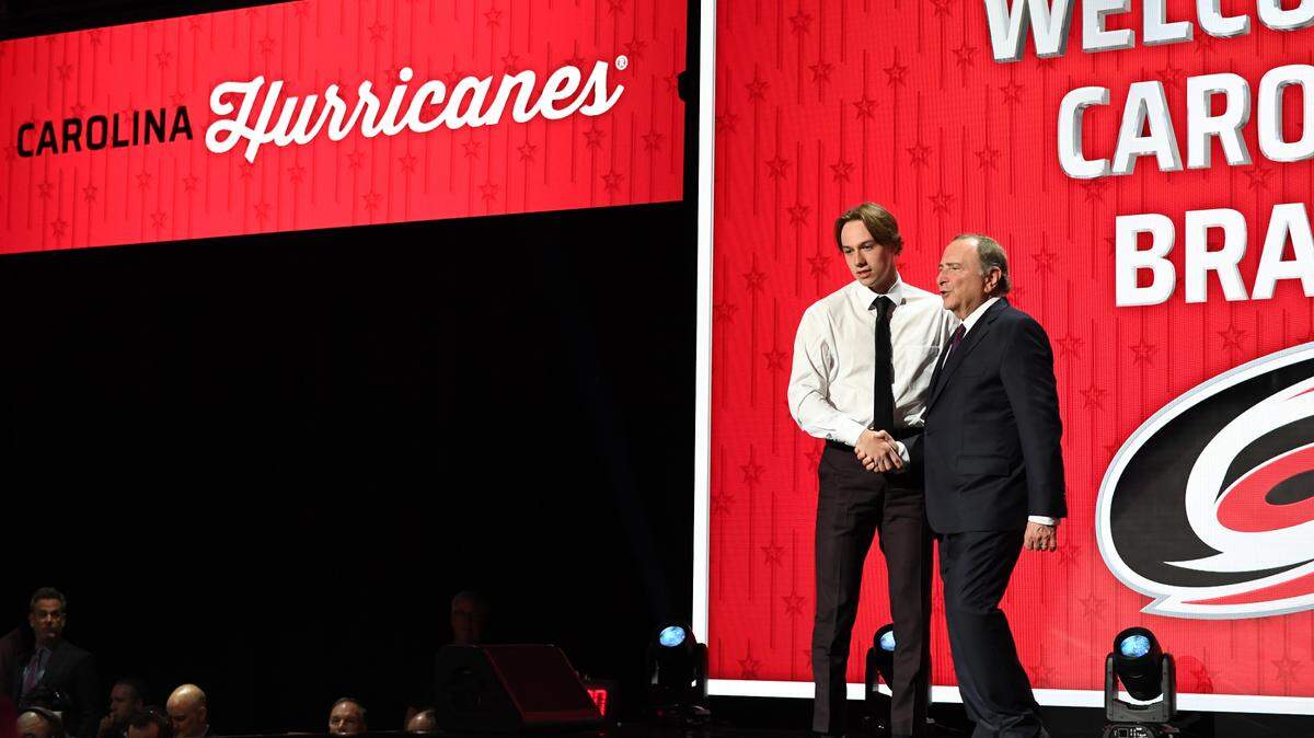 Carolina Hurricanes draft pick Bradly Nadeau shakes hands with NHL commissioner Gary Bettman after being selected with the thirtieth pick in round one of the 2023 NHL Draft at Bridgestone Arena.