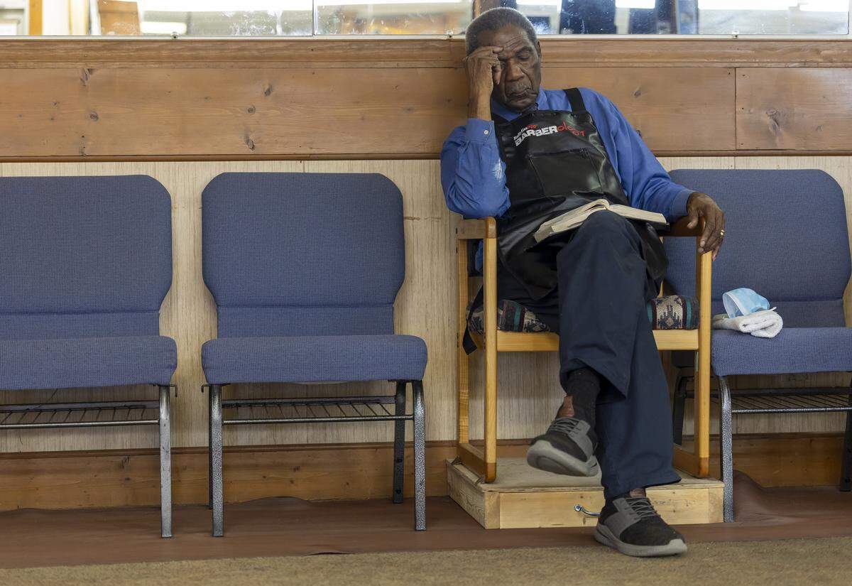 84-year-old Sylvester White reads the Bible between customers at White’s Barber Shop on Thursday, May 15, 2025 in Raleigh, N.C. White has operated this shop since 1967, he is also a pastor to a congregation in Castalia, N.C. 