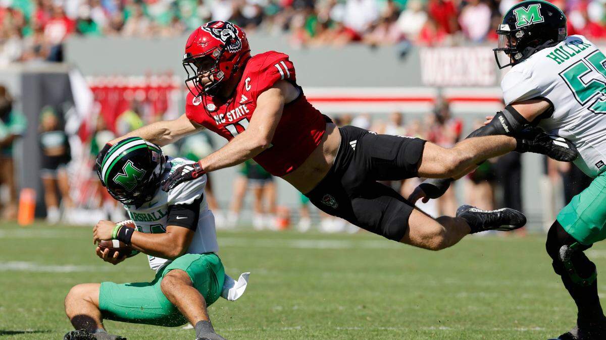 N.C. State linebacker Payton Wilson (11) tackles Marshall quarterback Cam Fancher (14) during their game at Carter-Finley Stadium on Saturday, Oct. 7, 2023.
