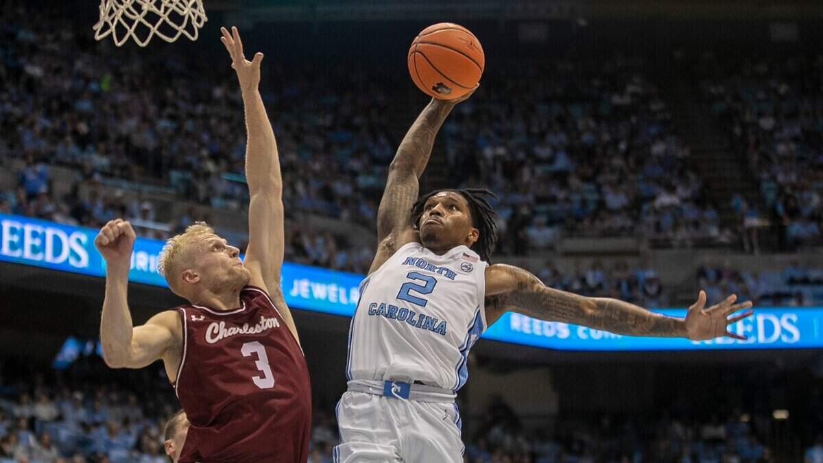 North Carolina’s Caleb Love (2) drives against College of Charleston’s Dalton Bolon (3) for a dunk during the first half on Friday, November 11, 2022 at the Smith Center in Chapel Hill, N.C.