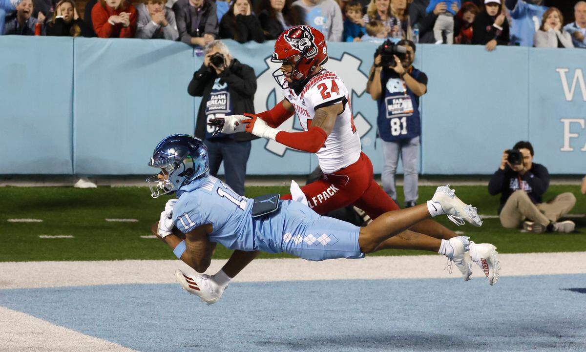 North Carolina wide receiver Josh Downs (11) makes the catch but cannot bring it in inbounds as N.C. State cornerback Derrek Pitts Jr. (24) defends during overtime of N.C. State’s 30-27 overtime victory over UNC at Kenan Stadium in Chapel Hill, N.C., Friday, Nov. 25, 2022.