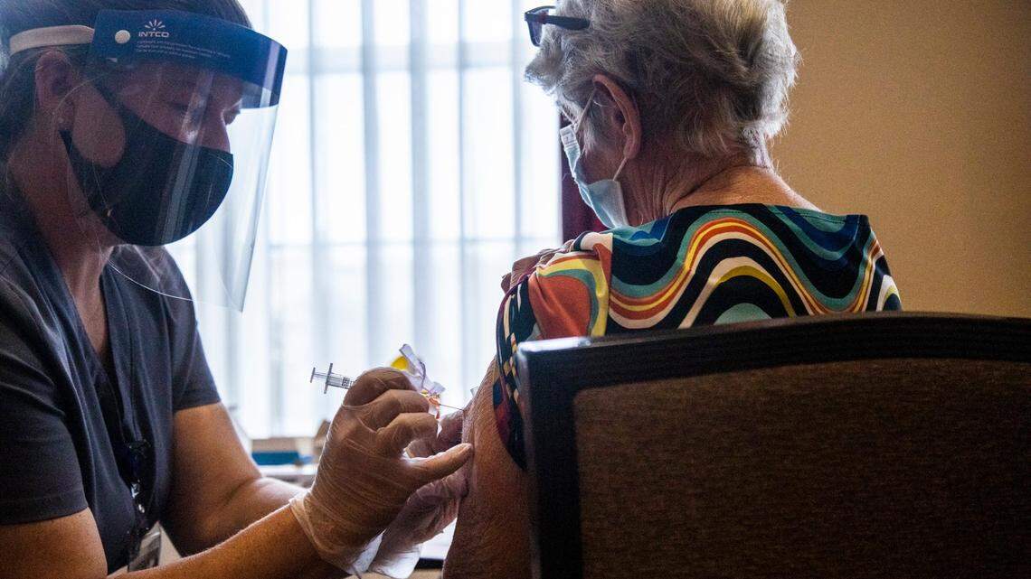 Pharmacy intern Angela Bishop, left, administers a coronavirus vaccine to Sheila Routh, 84, at Searstone Retirement Community in Cary Monday, Dec. 28, 2020.
