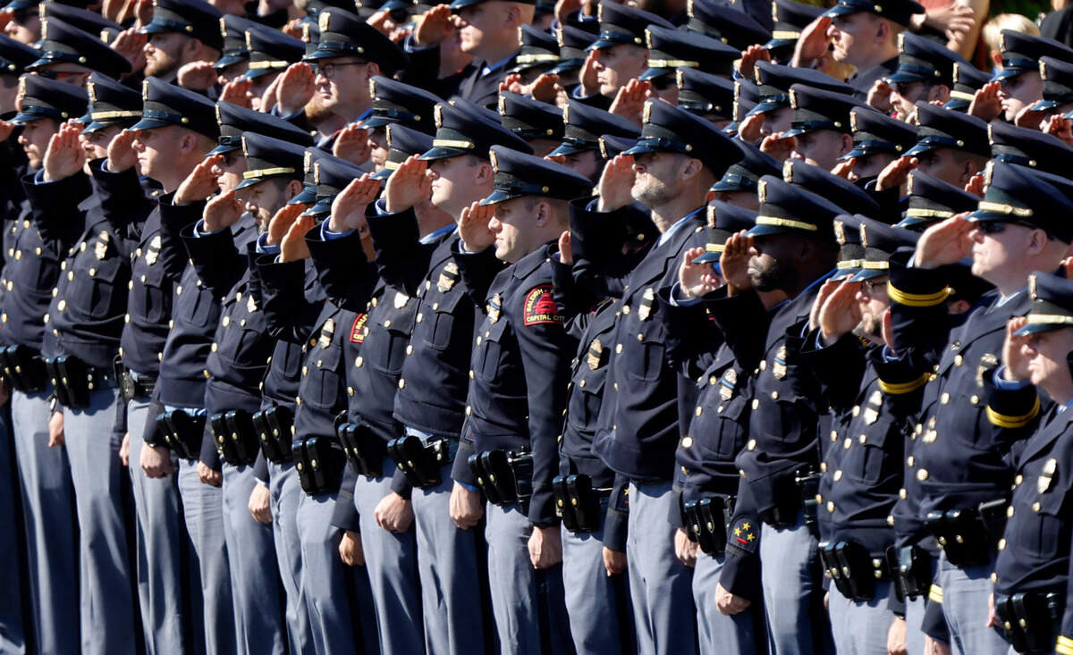 Raleigh Police officers salute as a funeral caisson transporting the casket of Raleigh Police Officer Gabriel Torres passes them outside Cross Assembly Church in Raleigh, N.C. Saturday, Oct. 22, 2022. Officer Torres was killed during a mass shooting Oct. 13.