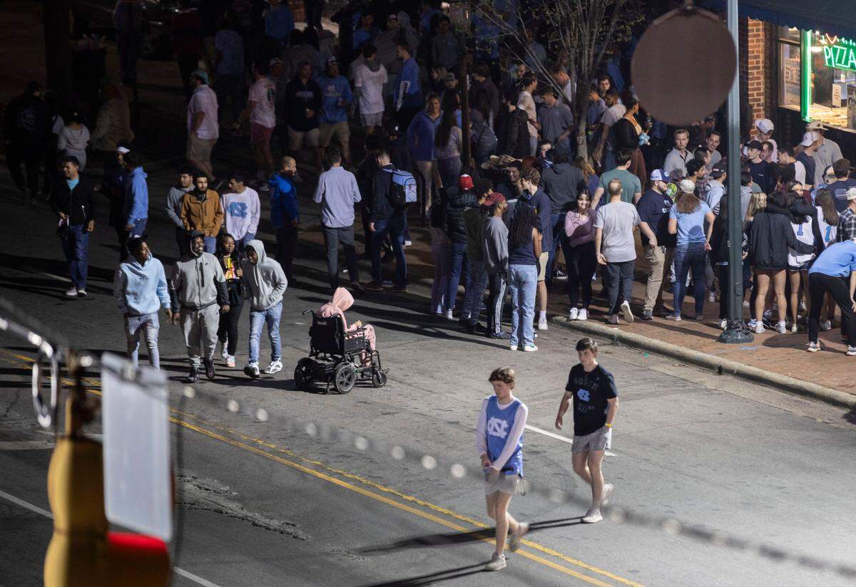 Tar Heel fans on Franklin Street in Chapel Hill, N.C. grapple with UNC’s loss to Kansas in the NCAA Championship game on Monday, April 4, 2022.