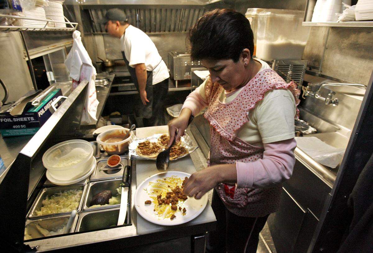 Ismael Santillano-Carrillo and his wife Norma Lazaro prepare an order in their former taco truck, which operated in 2008 at the former Johnny’s Sporting Goods in Carrboro. The couple will help their son-in-law open an “upscale taco restaurant” in 2022 in Chapel Hill.