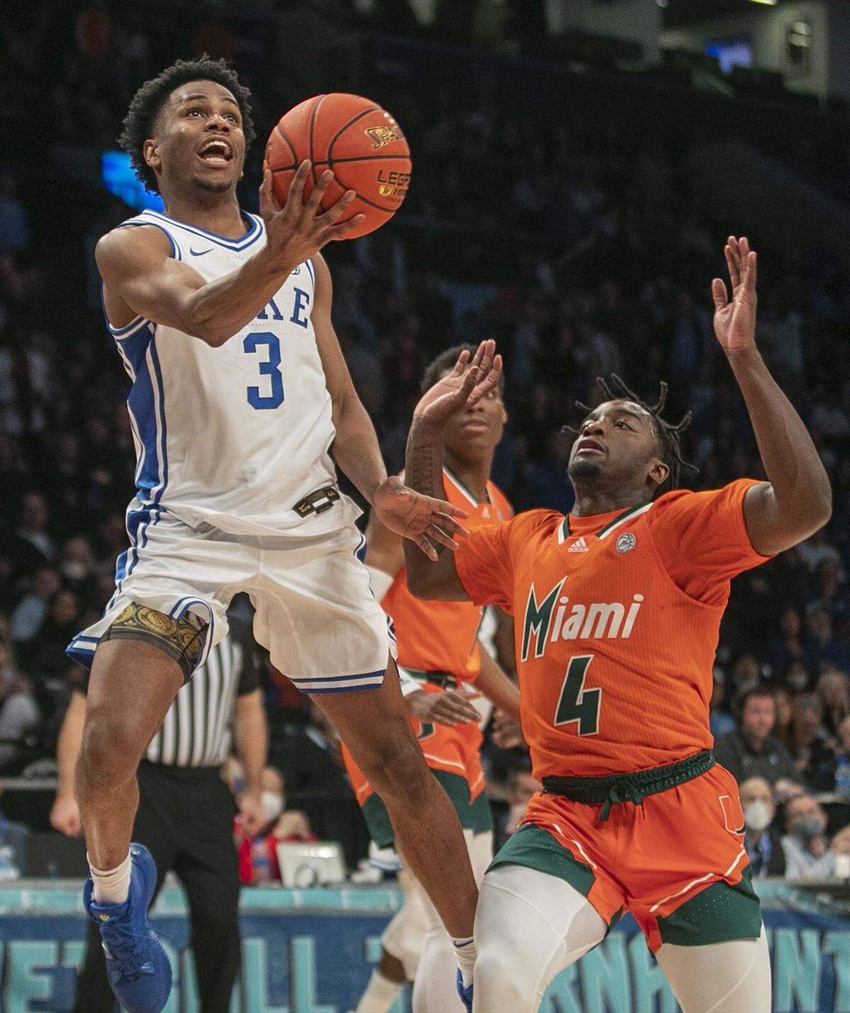 Dukes Jeremy Roach (3) drives to the basket against Miamis Bensley Joseph (4) to tie the score 36-36 at the half, in the semi-finals of the ACC Tournament on Friday, March 11, 2022 at Barclays Center in Brooklyn, N.Y.