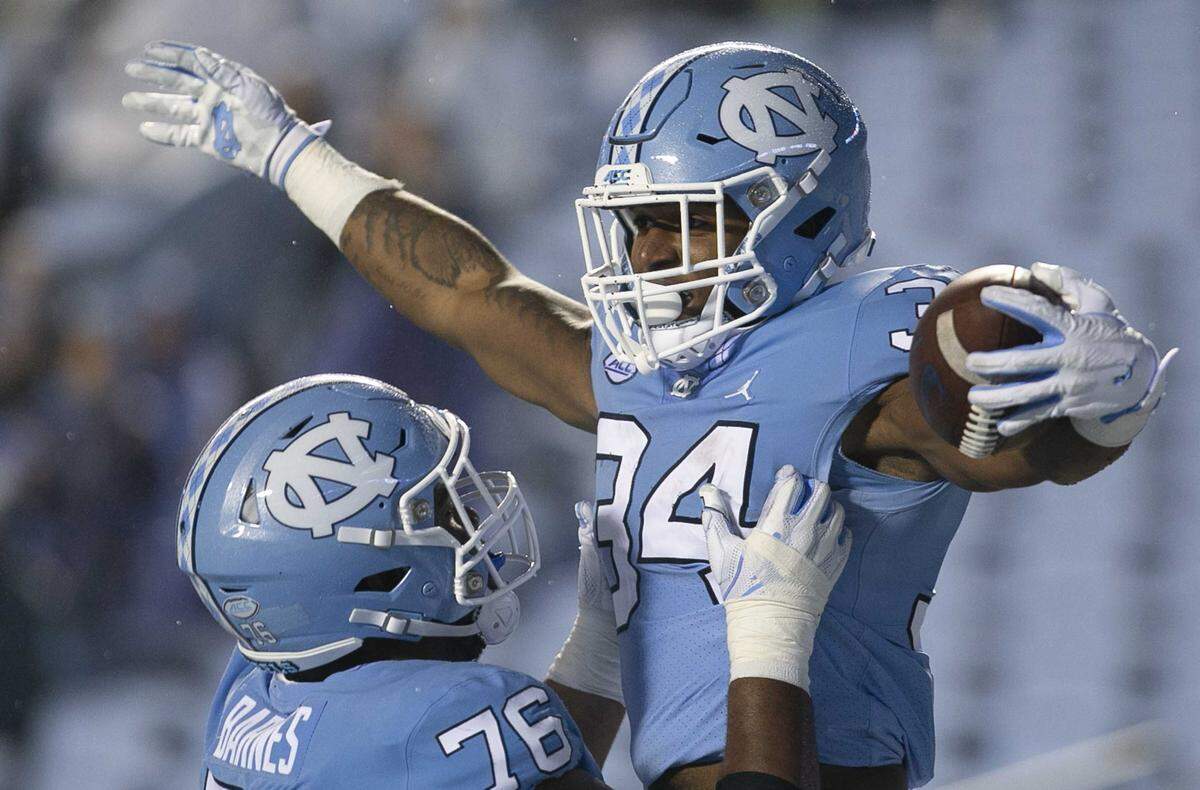 North Carolina’s British Brooks (34) celebrates with teammate Williams Barnes (76) after scoring on a 12 yard run to put the Tar Heels’ up 56-0 in the third quarter on Saturday, November 23, 2019 at Kenan Stadium in Chapel Hill, N.C.