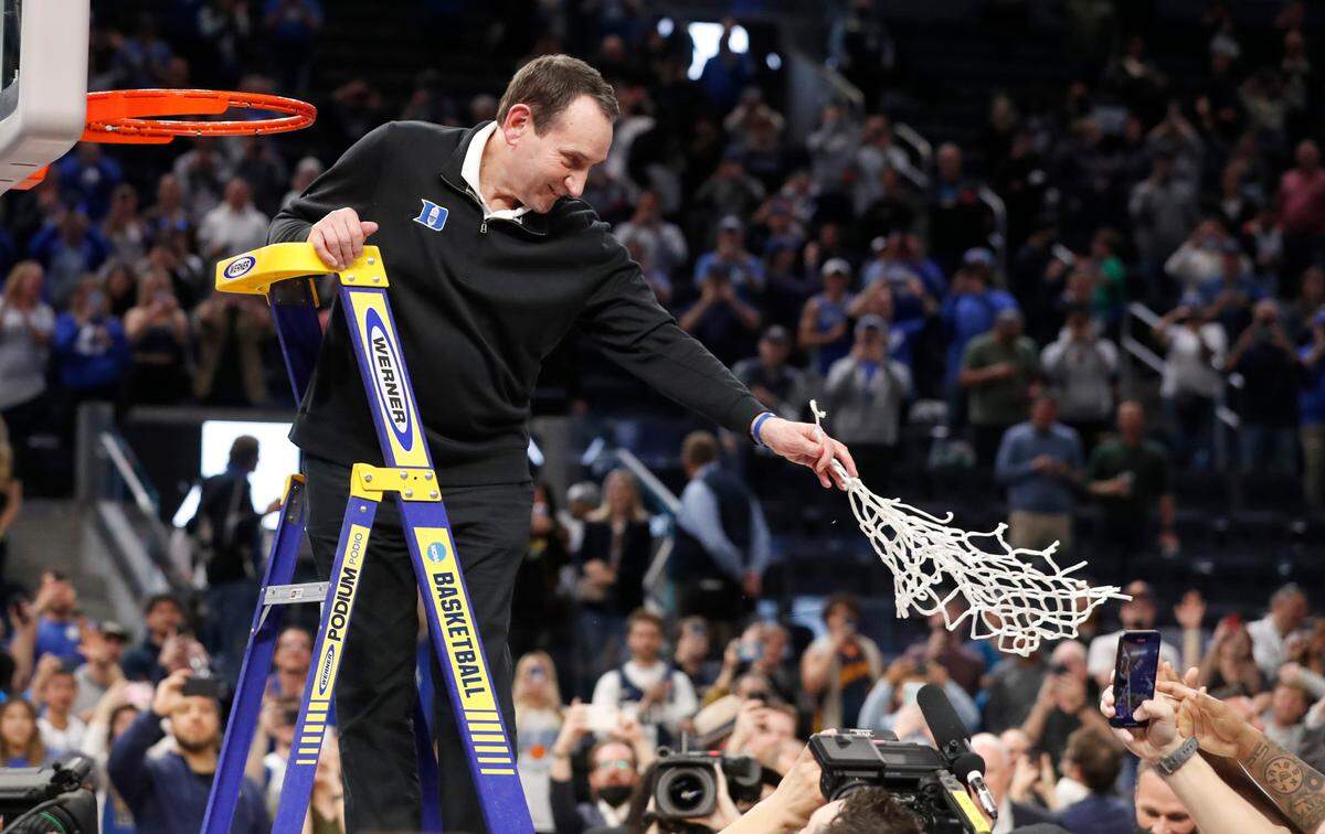 Duke head coach Mike Krzyzewski hands the net to his players after cutting it down after Duke’s 78-69 victory over Arkansas in the NCAA Tournament West Regional finals at the Chase Center in San Francisco, Calif., Saturday, March 26, 2022.