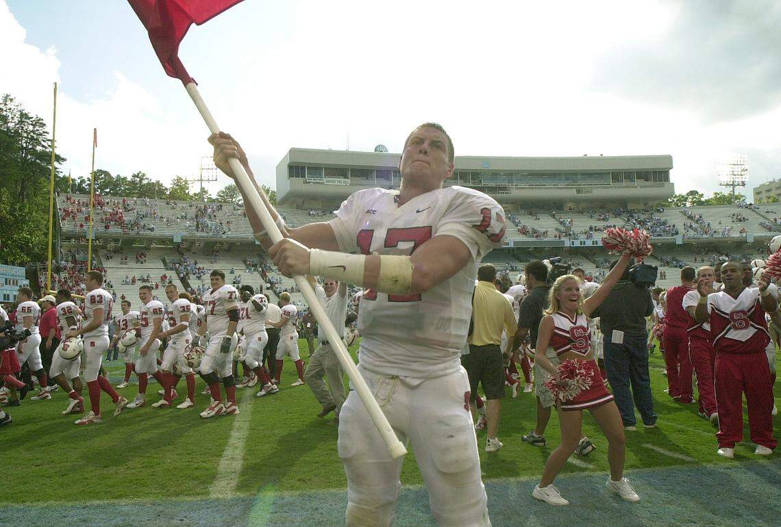 N.C. State quarterback Philip Rivers waves a State flag in Kenan Stadium after the Wolfpack defeated North Carolina 34-17 in 2002.