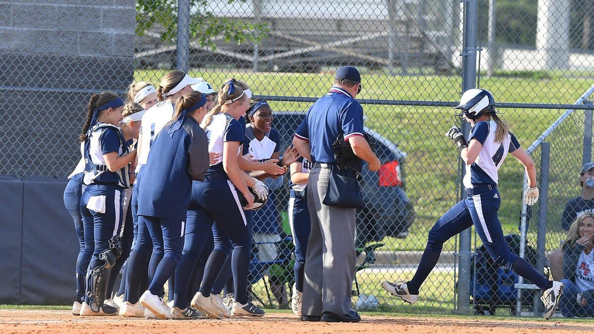 Lindsey Dorn, right, of Heritage steps on to the home plate after hitting a home run in the second inning. The Apex Friendship Patriots visited the Heritage Huskies in a high school softball game on May 14, 2019.